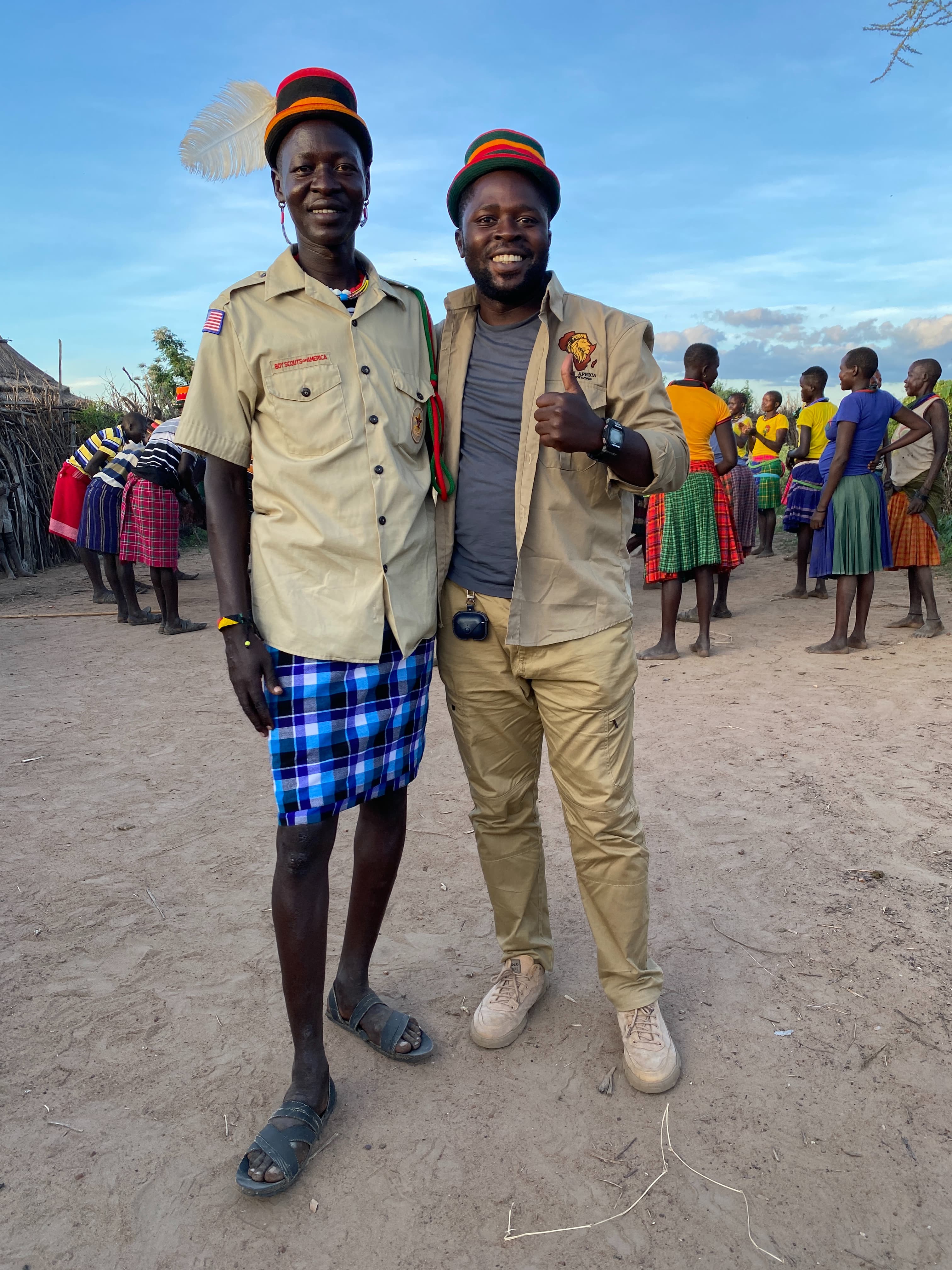 Okoth Benard holding a Sony camera outside a traditional Karamojong manyatta in Nadunget, Moroto Uganda
